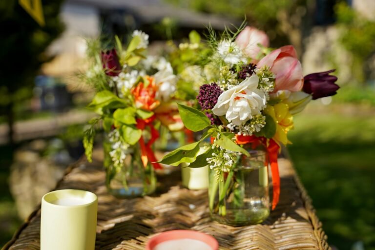 Bocaux en verre récupérés avec des fleurs colorées sur une surface en bois